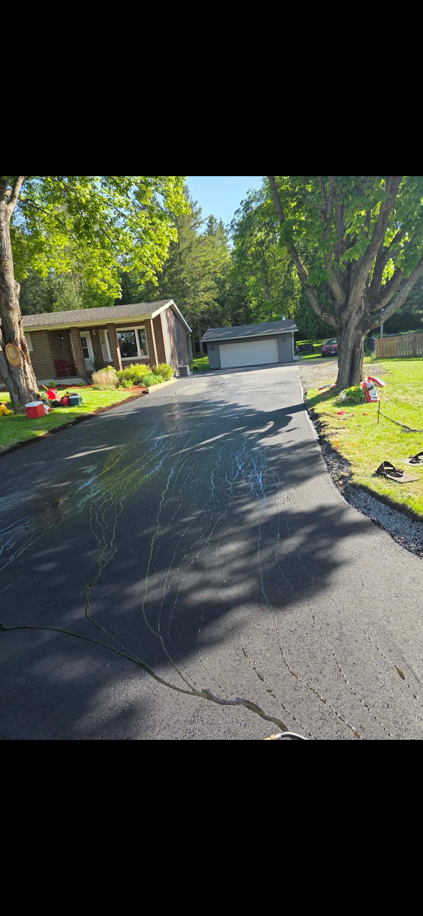 Sealcoating in progress — driveway curing dark