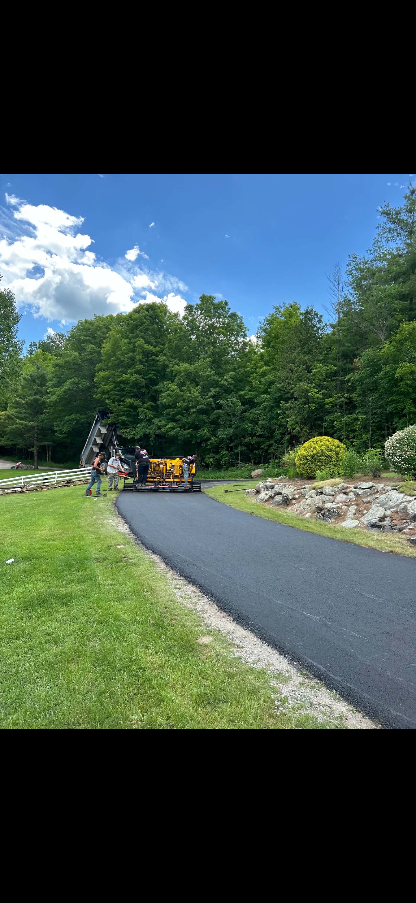 Fresh asphalt driveway paving through the trees