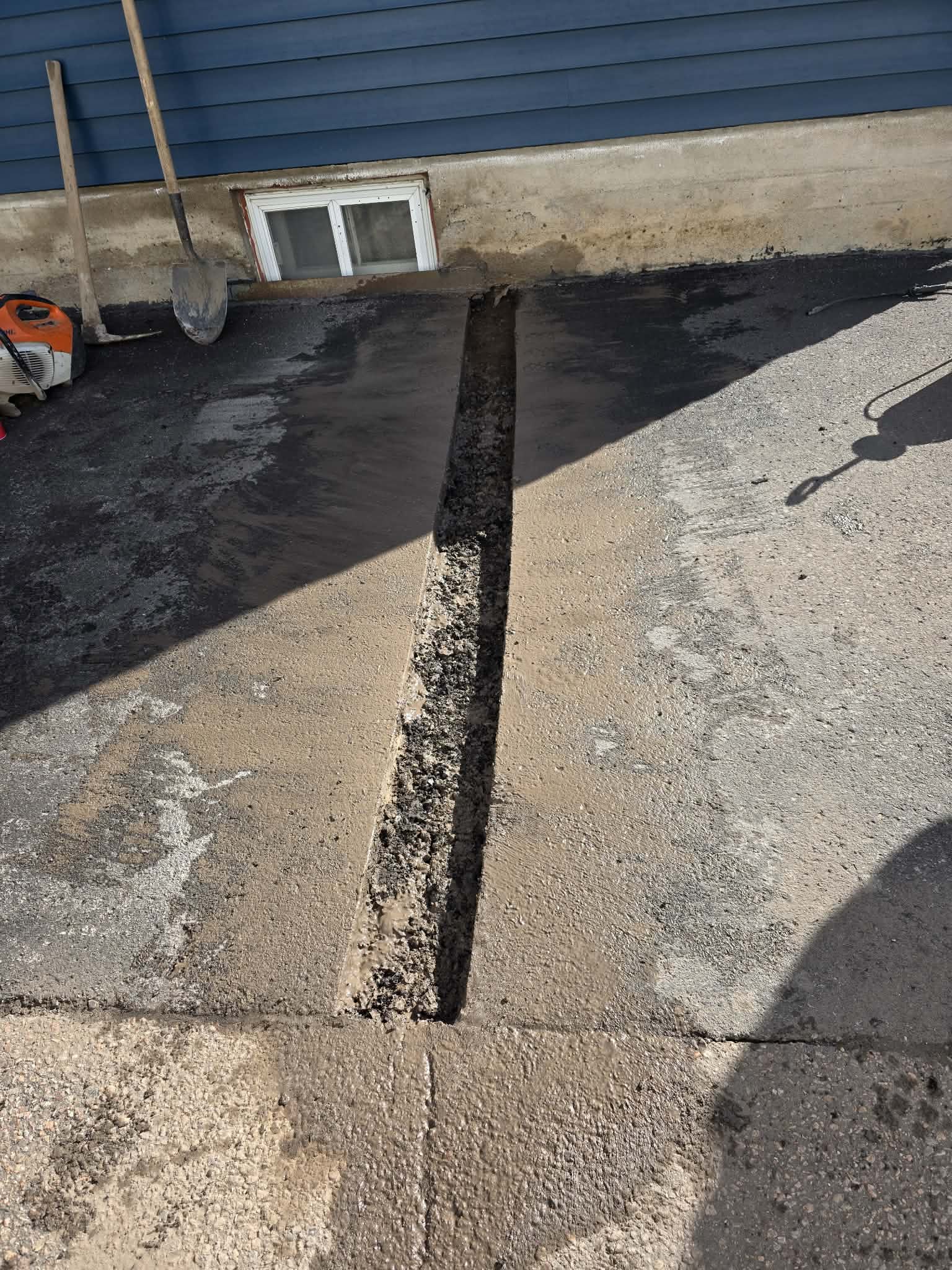 Concrete slab crack repair with asphalt fill